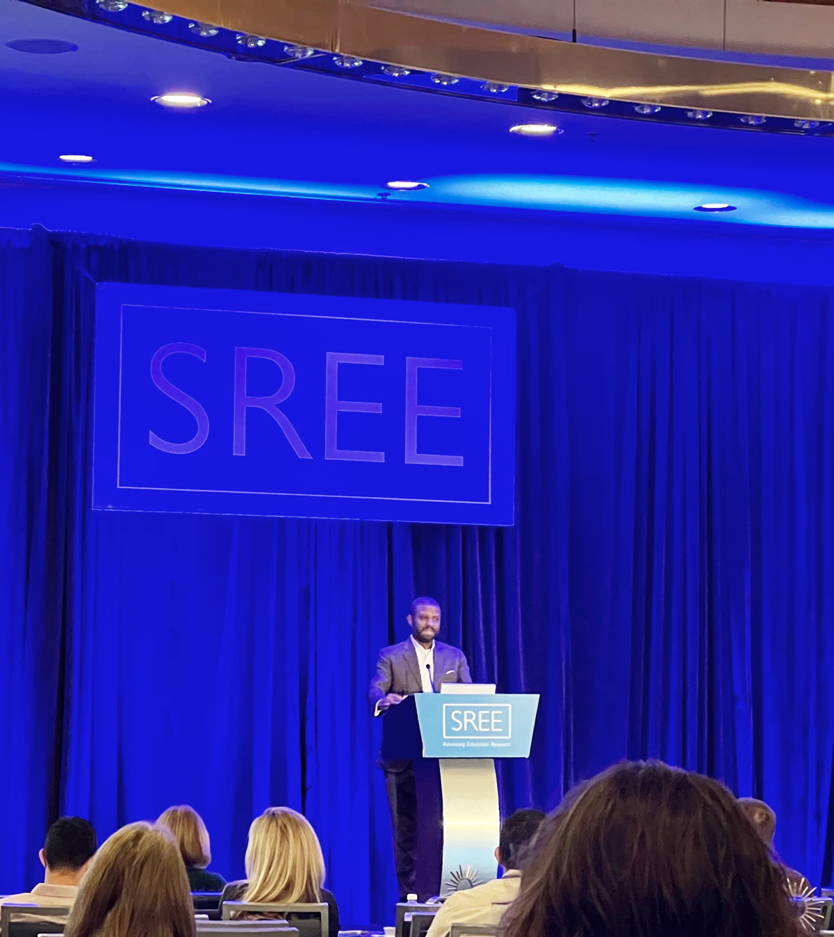 Dr. Ivory Toldson at a podium presenting at SREE